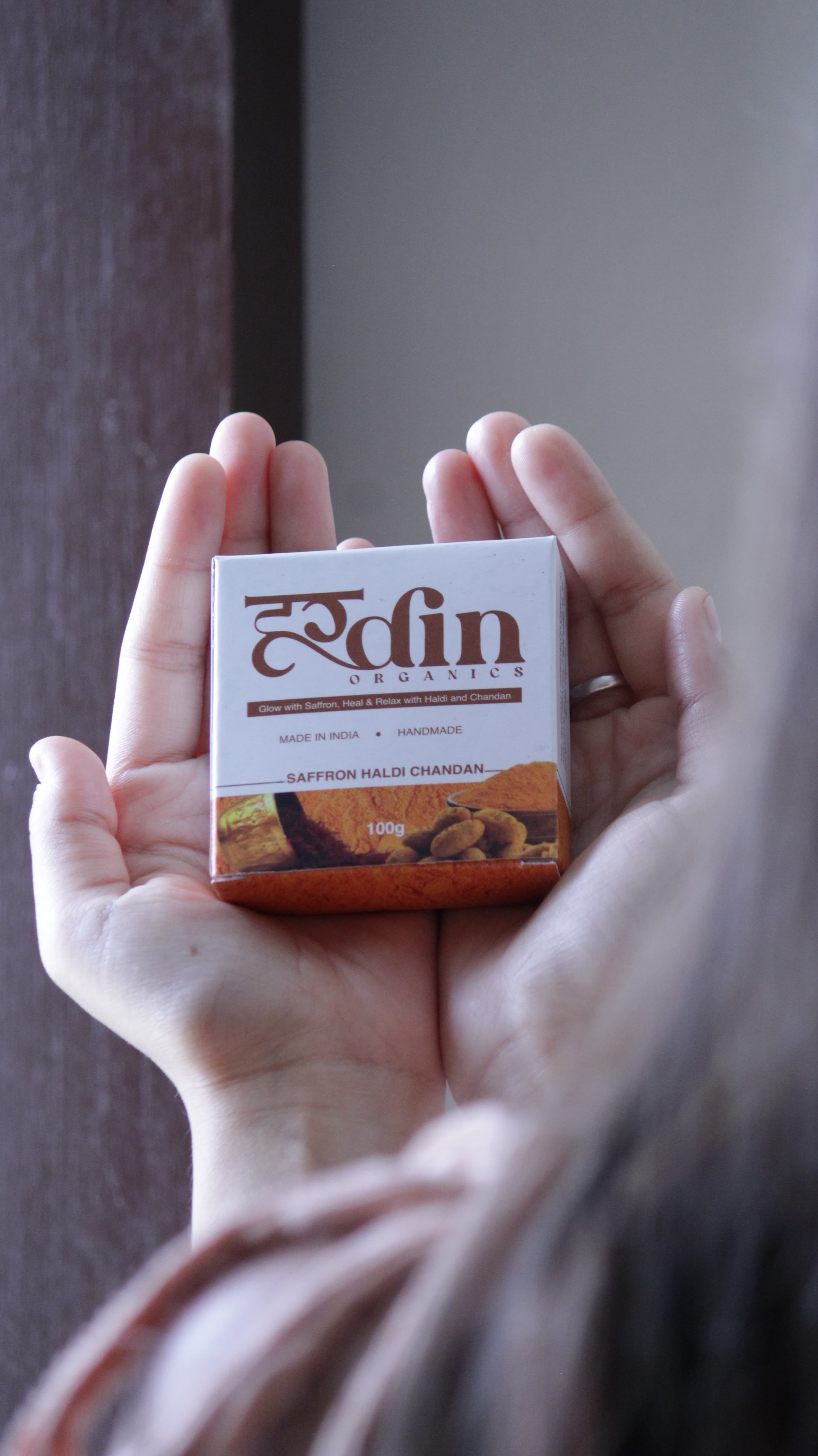 Hardin Organics handcrafted Saffron Haldi Chandan soap held in hands